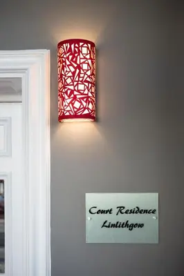 a red light on a wall next to a door at Court Residence Aparthotel in Linlithgow