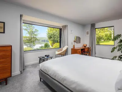 a bedroom with a bed and a large window at Carsaig in Port of Menteith