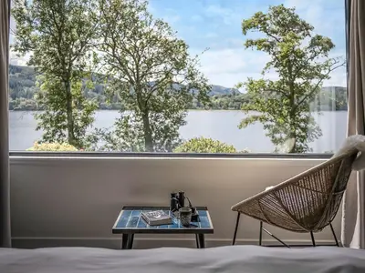 a room with a bed and a table and a window at Carsaig in Port of Menteith