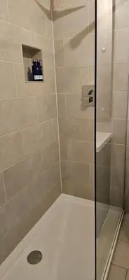 a shower with a glass door and a shower at Butt Lodge in Lochranza