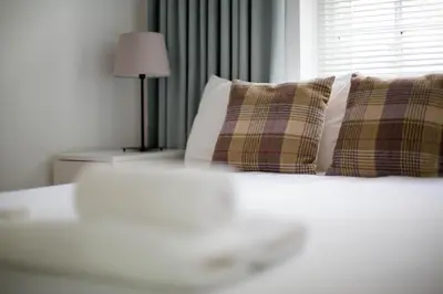 a bedroom with a bed with pillows and a window at Modern Grassmarket Apartment in Edinburgh