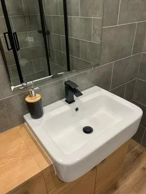 a white sink in a bathroom with a mirror at Modern Grassmarket Apartment in Edinburgh