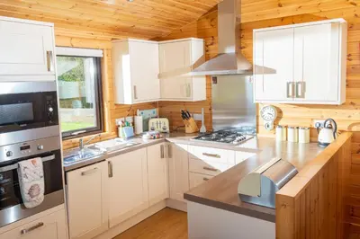 a kitchen with white cabinets and a stove at Linwater Caravan Park - Luxury Lodges and Static Caravans near Edinburgh in Newbridge