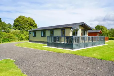 a small house with a porch and a driveway at Linwater Caravan Park - Luxury Lodges and Static Caravans near Edinburgh in Newbridge