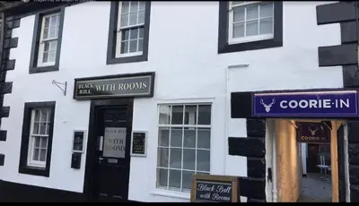 a white building with signs on the side of it at Black Bull with Rooms upper in Cumbernauld