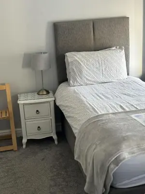 a bedroom with a bed with a lamp and a nightstand at Black Bull with Rooms upper in Cumbernauld