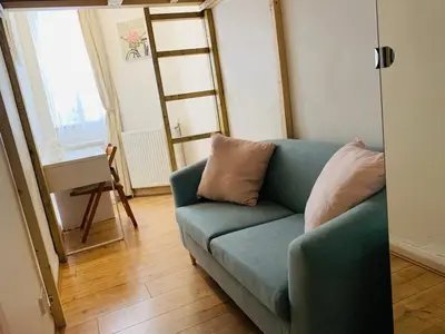 a living room with a blue couch and a ladder at Edinburgh Central Apartment in Edinburgh