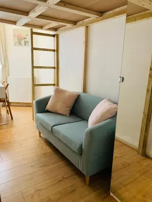 a living room with a blue couch and a mirror at Edinburgh Central Apartment in Edinburgh