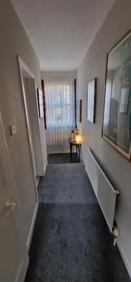 an empty hallway with a table and a window at Morris Terrace Apartment in Stirling