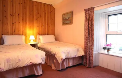 a bedroom with two beds and a window at Inverawe Cottages in Taynuilt