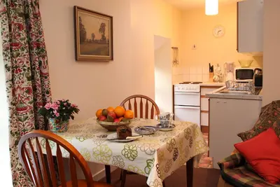 a kitchen with a table with a bowl of fruit on it at Inverawe Cottages in Taynuilt