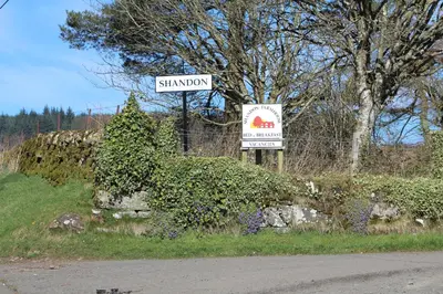 a street sign with a bush on the side of a road at Shandon Farmhouse Bed and Breakfast in Drymen