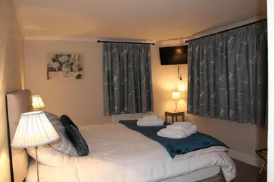 a bedroom with a bed and two lamps and a window at Shandon Farmhouse Bed and Breakfast in Drymen