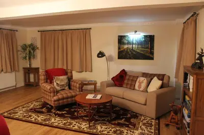 a living room with a couch and chairs and a table at Shandon Farmhouse Bed and Breakfast in Drymen