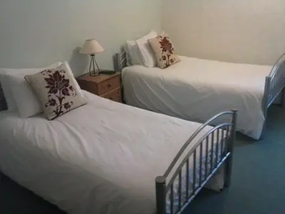 a bedroom with two beds and a table with a lamp at Lochgair Hotel in Lochgair