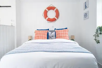 a bedroom with a bed with a lifesaver on the wall at The Foresters Guest House in Inverkip