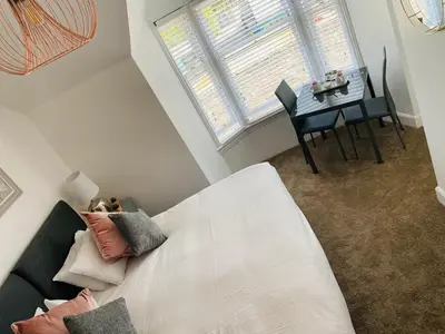 a living room with a bed and a table with a dining room at The Foresters Guest House in Inverkip