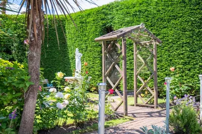 a small wooden structure in a garden with flowers at The Foresters Guest House in Inverkip