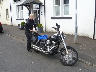 a man is standing next to a motorcycle at The Foresters Guest House in Inverkip