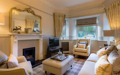 a living room with a couch and a fireplace at Crossbasket Castle, Hotel & Restaurant in High Blantyre
