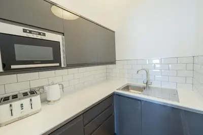 a kitchen with a sink and a microwave at Edinburgh Castle Apartments in Edinburgh