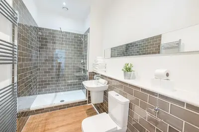 a bathroom with a toilet and a shower and a sink at Edinburgh Castle Apartments in Edinburgh