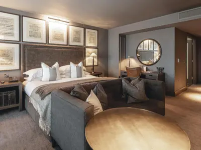 a bedroom with a bed and a couch and a table at Dakota Glasgow in Glasgow