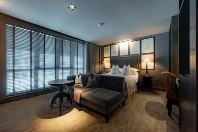 a bedroom with a bed and a couch and a table at Dakota Glasgow in Glasgow