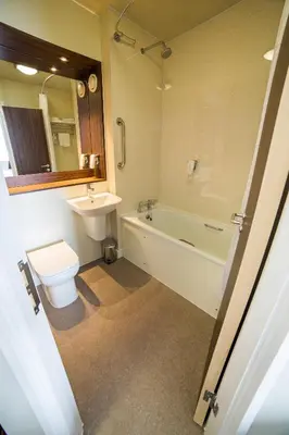 a bathroom with a sink and a toilet and a bath tub at Red Squirrel, Stevenston by Marston's Inns in Stevenston