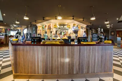 a bar in a restaurant with a wooden counter at Red Squirrel, Stevenston by Marston's Inns in Stevenston