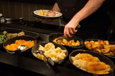 a person standing in a kitchen preparing food at Red Squirrel, Stevenston by Marston's Inns in Stevenston