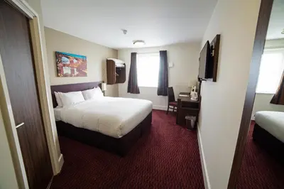 a hotel room with a bed and a television at Red Squirrel, Stevenston by Marston's Inns in Stevenston