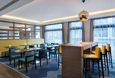 a restaurant with tables and chairs and windows at Hampton by Hilton Glasgow Central in Glasgow