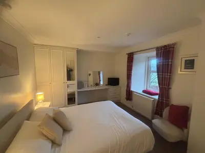 a bedroom with a large bed and a window at Airds Farm Guest House in Castle Douglas