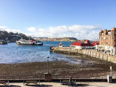 a boat is docked at a dock in the water at Argyll Mansions in Oban