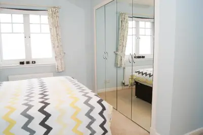a bedroom with a bed and a mirror at Wood Court, Troon in Troon