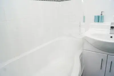 a white bathroom with a sink and a toilet at Wood Court, Troon in Troon