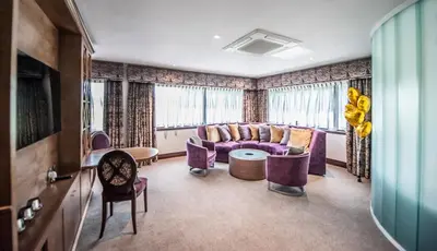 a living room with a purple couch and chairs at Parklands Hotel & Country Club in Newton Mearns