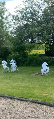 a group of white sculptures in the grass at Fox House Thirdpart Farm in Beith