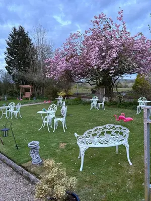 a yard with white chairs and a tree with pink flowers at Fox House Thirdpart Farm in Beith