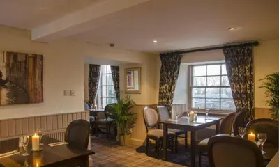 a restaurant with tables and chairs in a room at The Inn at Kippen in Kippen