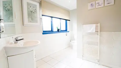 a white bathroom with a sink and a toilet at The Inn at Kippen in Kippen