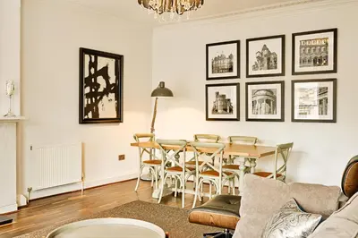 a living room with a table and chairs at JOIVY Luxury Flats on George Street in Edinburgh