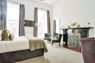 a bedroom with a bed and a fireplace at JOIVY Luxury Flats on George Street in Edinburgh