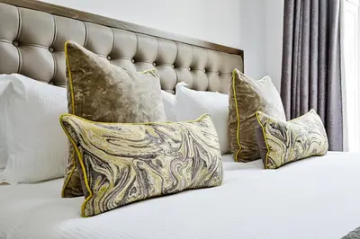 a bed with a bunch of pillows on it at JOIVY Luxury Flats on George Street in Edinburgh