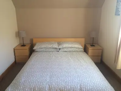a bedroom with a large bed with two night stands at Park View in Ballachulish