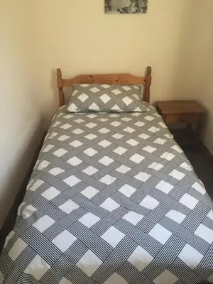 a bed with a blue and white comforter in a bedroom at Park View in Ballachulish