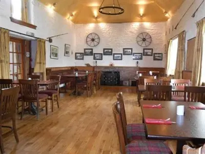 a dining room with tables and chairs in a restaurant at The Ken Bridge Hotel & Campsite in New Galloway