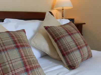two pillows sitting on a bed next to a lamp at The Ken Bridge Hotel & Campsite in New Galloway