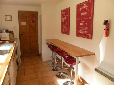 a kitchen with a wooden table and red stools at McHugh and Loudon Cottages in Saint Catherines